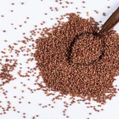 Buckwheat with spoon on them high angle view on a white background